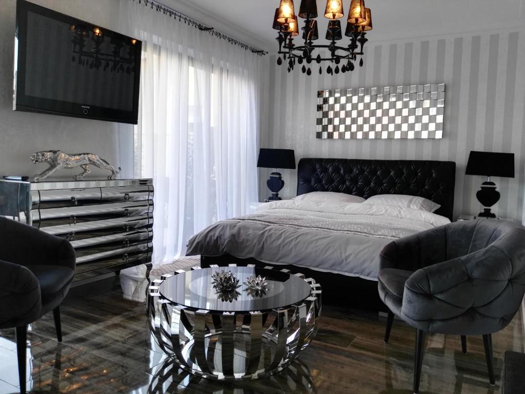 - une chambre avec un lit, deux chaises et une table dans l'établissement Apartamenty De Soleil, à Ustka