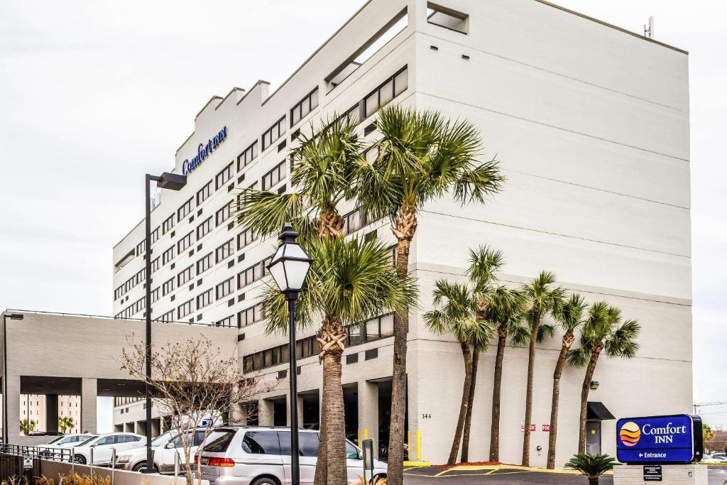 a building with palm trees in front of it at Comfort Inn Downtown Charleston in Charleston