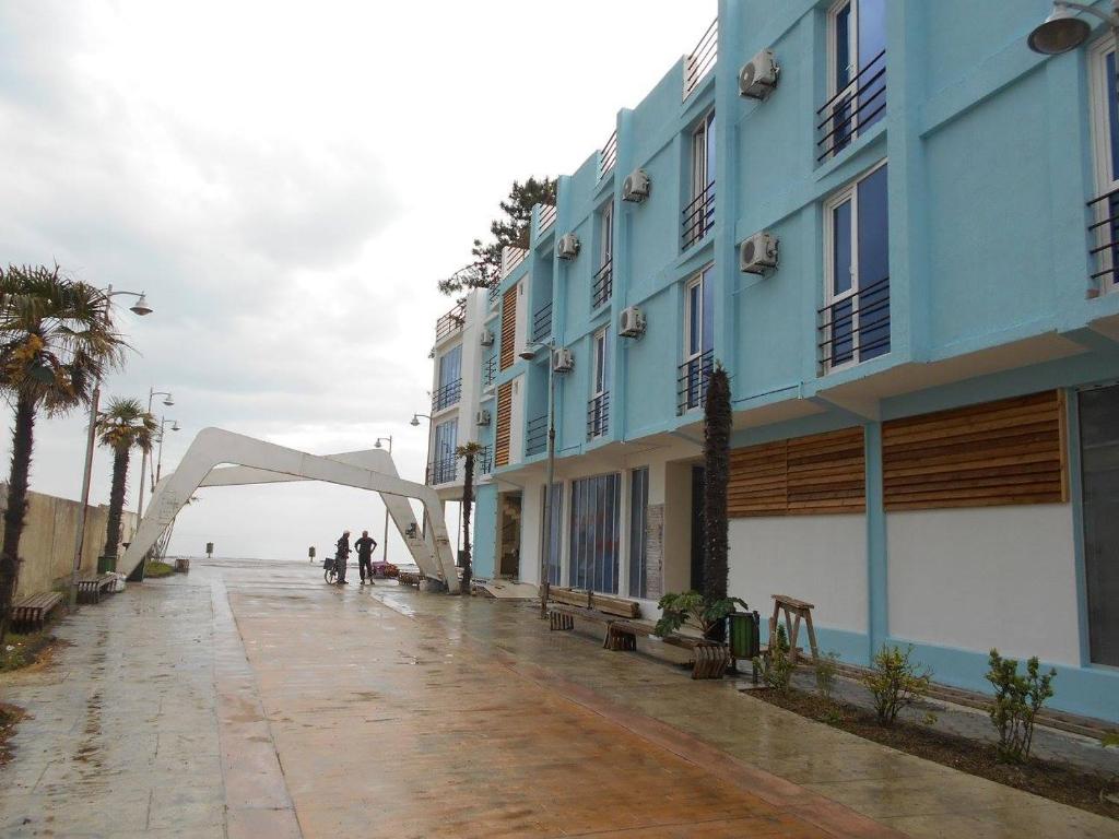 uma rua vazia com um edifício e palmeiras em Magnetic Sand Hotel em Ureki