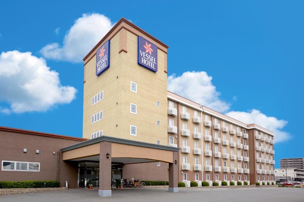 a hotel building with a sign on top of it at Vessel Hotel Fukuoka Kaizuka in Fukuoka