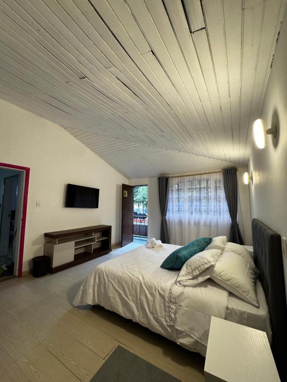 a bedroom with a large bed with a ceiling at Casa Cocora in Bogotá