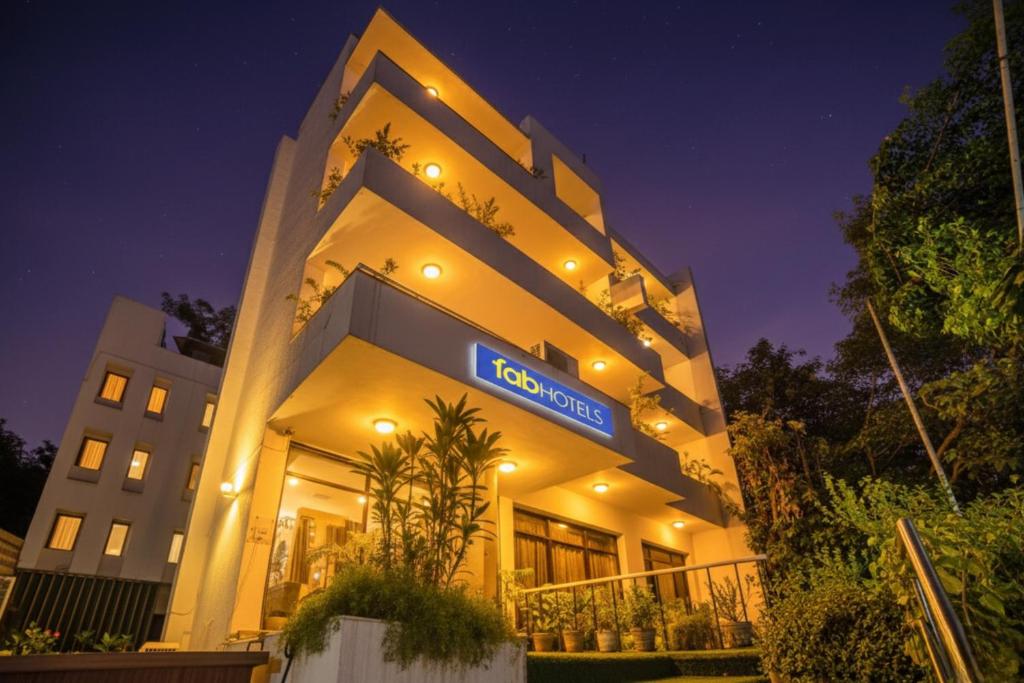 a hotel building with a sign on it at night at FabHotel BMK Grand in New Delhi