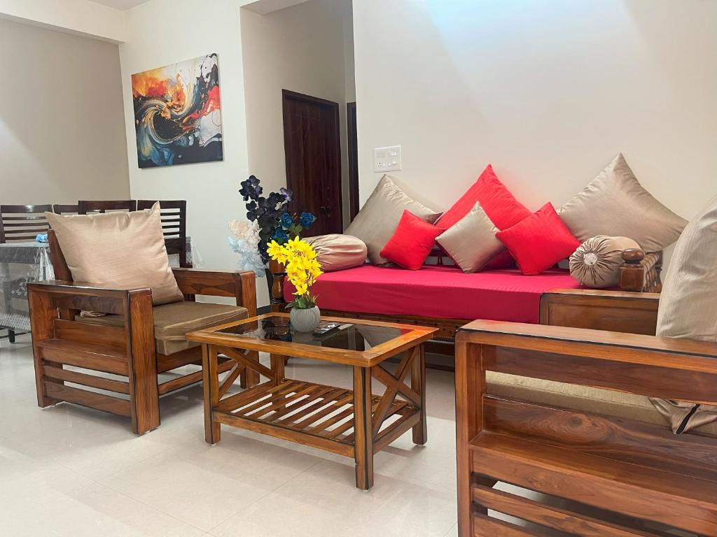 a living room with a red couch and chairs at 2 BHK Gachibowli AIG #102 in Hyderabad