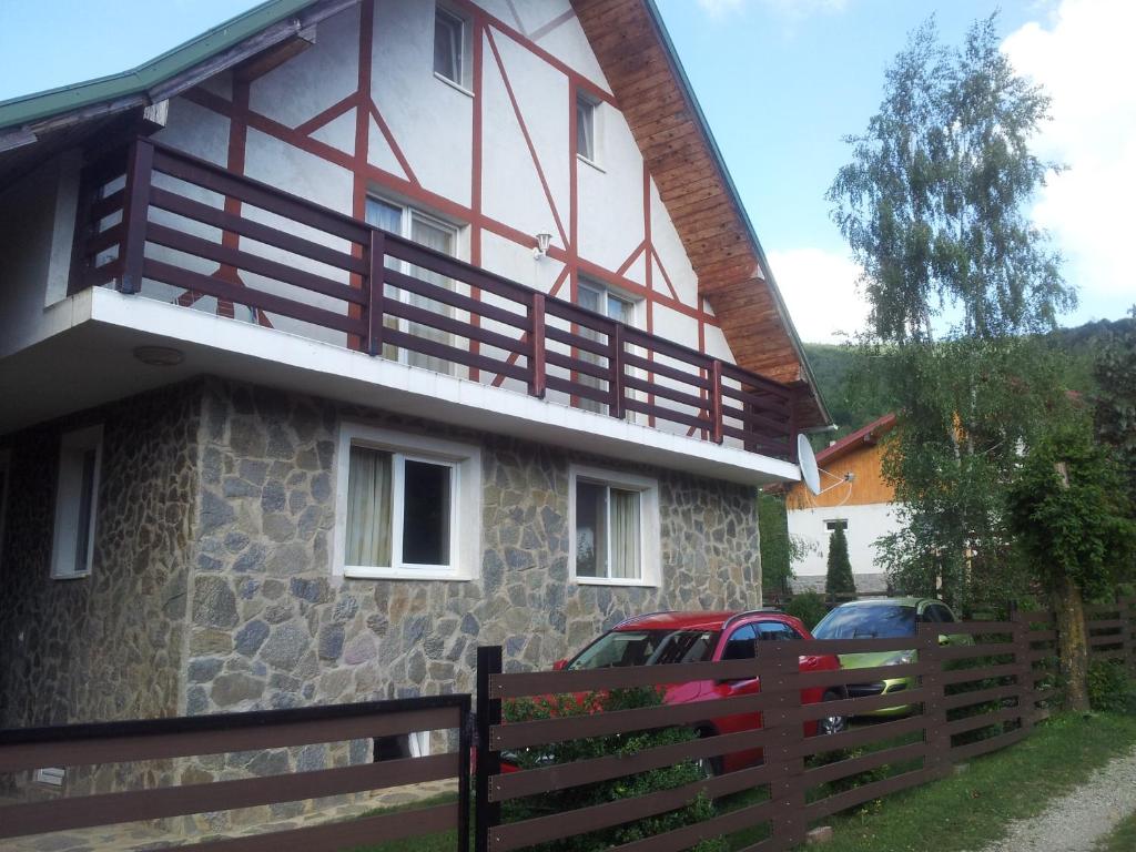 a house with a fence in front of it at Cabana Ninel in Văliug