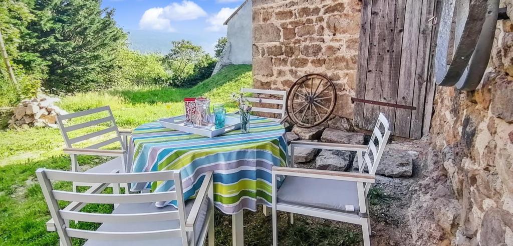 a table and chairs on a patio with a wheel at Gîte Chez Amélie in Le Monestier