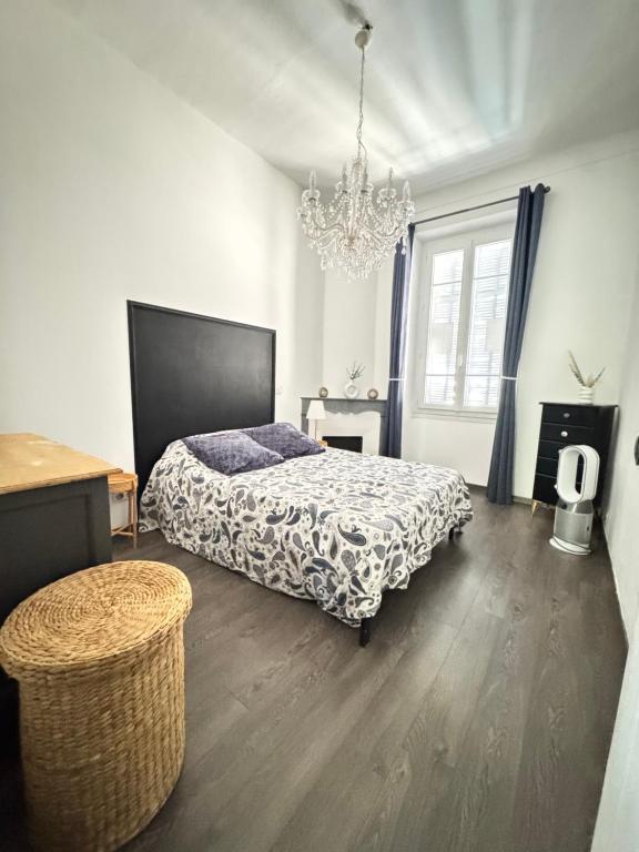 a bedroom with a bed and a chandelier at Appartement Bourgeois à 5 min à pied du centre in Cannes