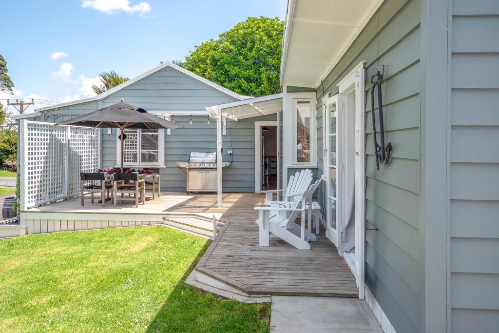 a porch of a house with a table and an umbrella at Quintessential Russell Cottage in Russell