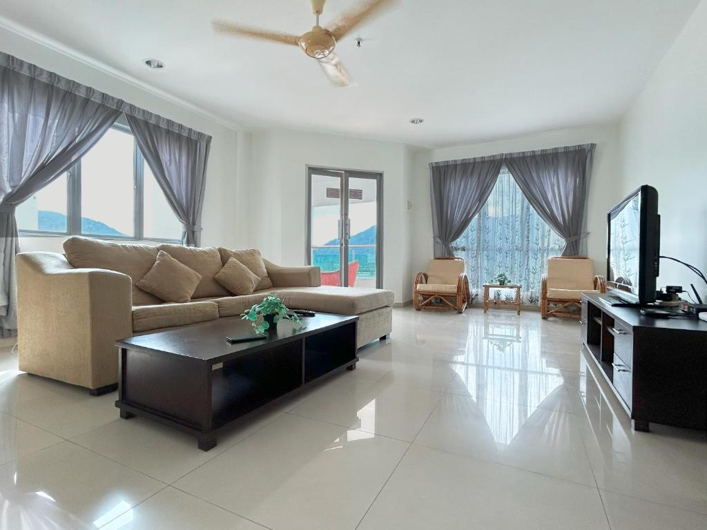 a living room with a couch and a tv at D'Sea Marina Island Resort by Manhattan Group in Lumut