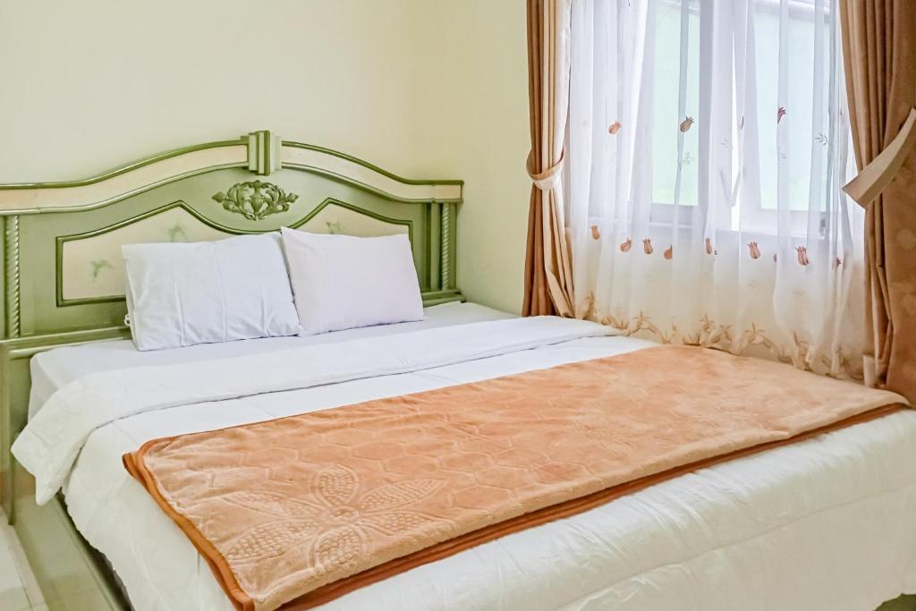 a bedroom with a large bed with a large window at Homestay Nusa Indah 2 Syariah at Dieng 0 KM RedPartner in Dieng