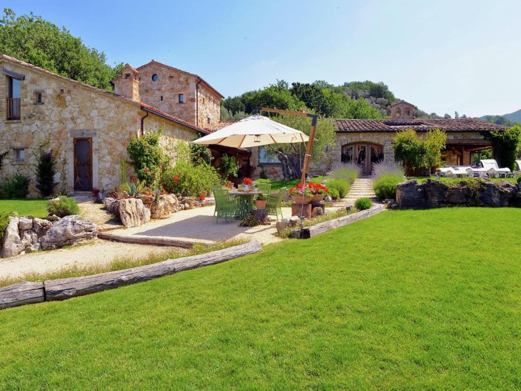 a garden with a table and an umbrella at Villa Solace - Comfort Charm in Guardea