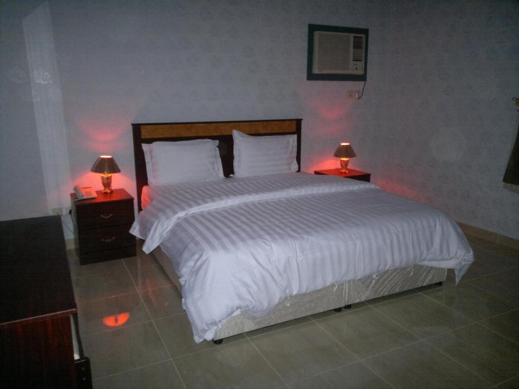 a bedroom with a large white bed with two lamps at شقق مفروشه خاصة وضيافه 6699 in Yanbu