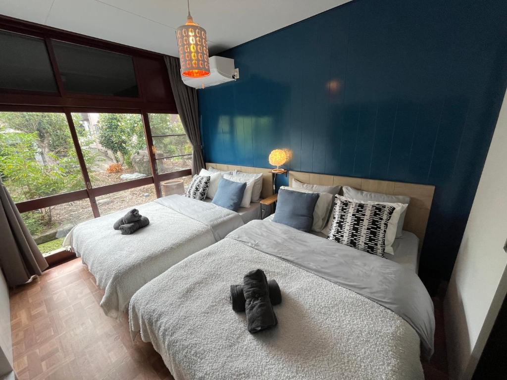 a bedroom with two beds with stuffed animals on them at 伊勢ブルーヴィラ本館と離れ in Ise