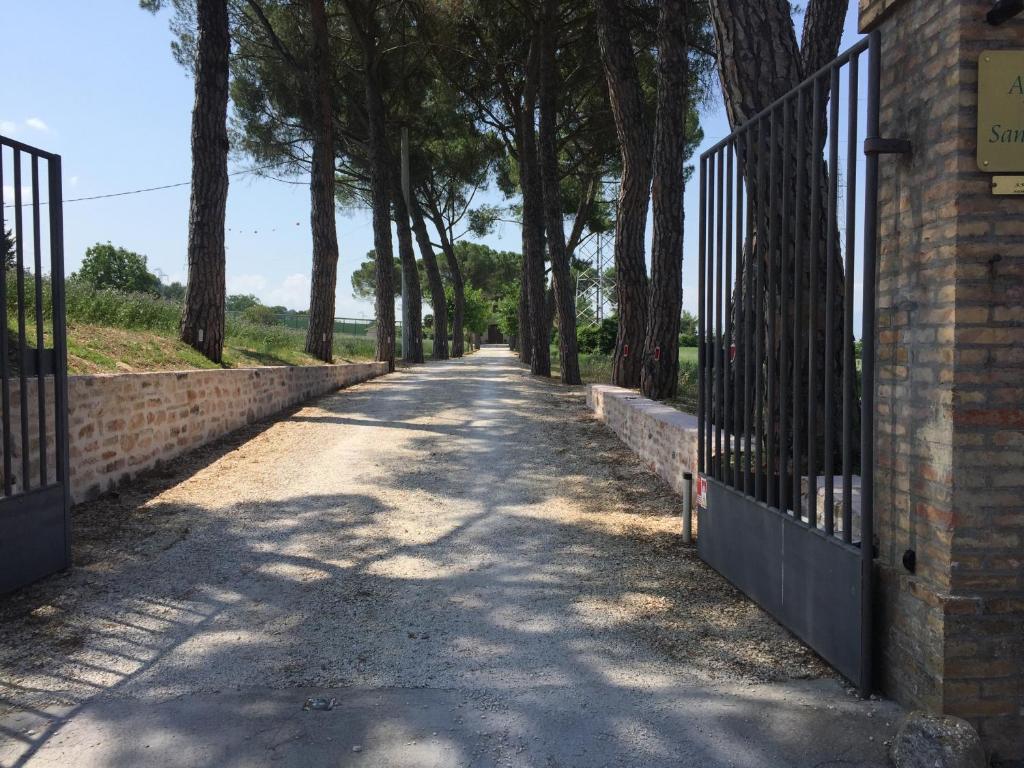 un camino vacío con una valla y árboles en Residenza San Bartolomeo en Foligno