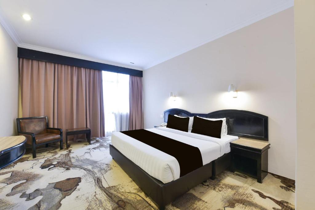 a hotel room with a bed and a chair at Sunday Malacca Formerly Tun Fatimah in Malacca