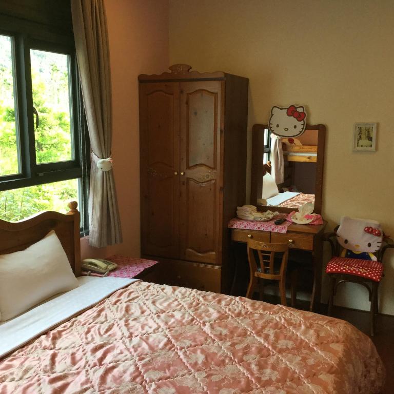 a bedroom with a bed and a desk and a mirror at 闕麒景觀民宿Chill Villa B&amp;B in Puli