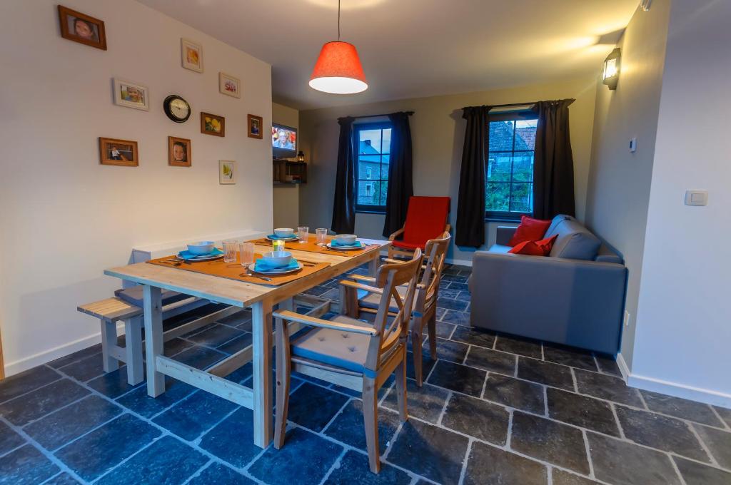 een eetkamer met een tafel en stoelen en een bank bij Het Kloosterzicht in Borgloon