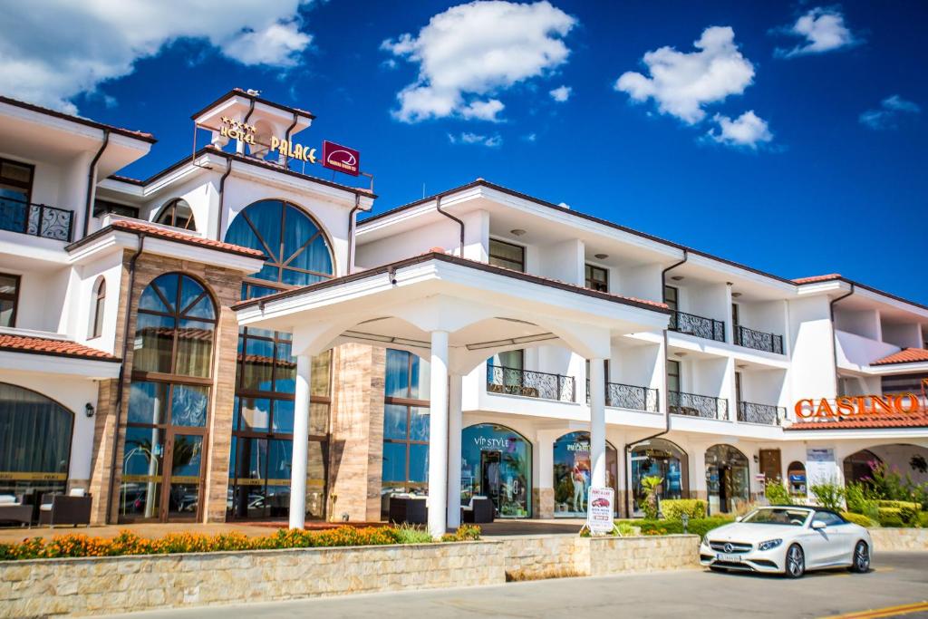 een witte auto geparkeerd voor een gebouw bij Hotel Palace Marina Dinevi in Sveti Vlas
