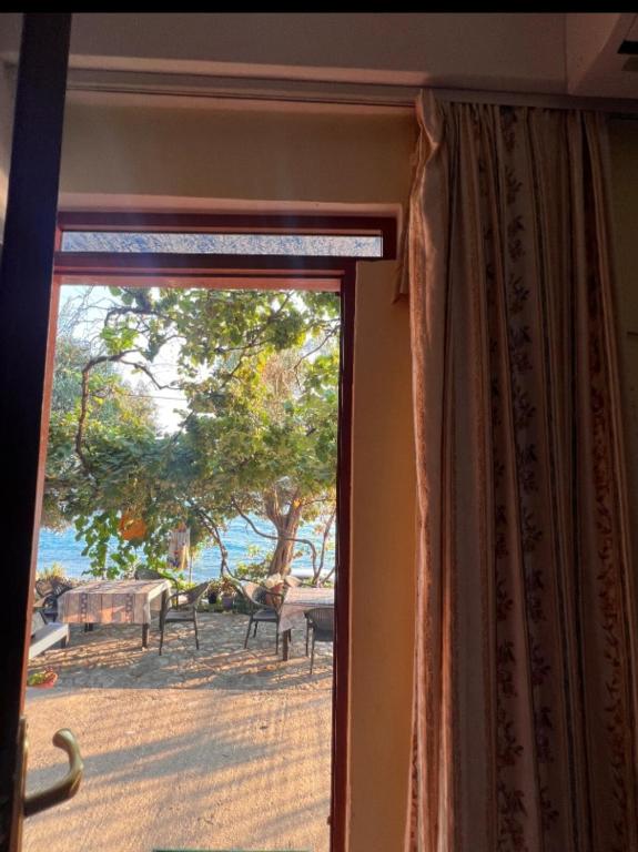 a sliding glass door with a view of a yard at Room zero of Sea in Borsh