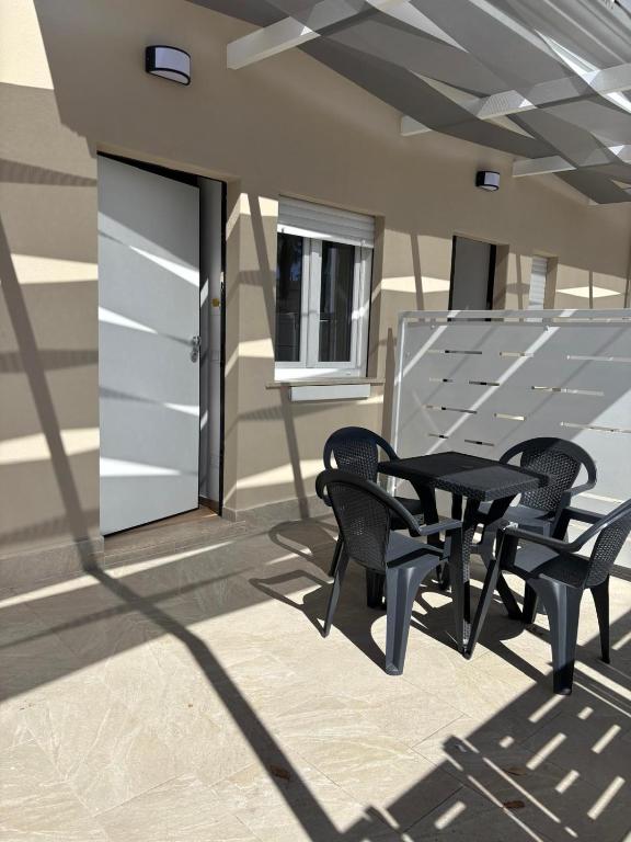 a patio with chairs and a table and a door at Don Rosario in Stazione di Paestum