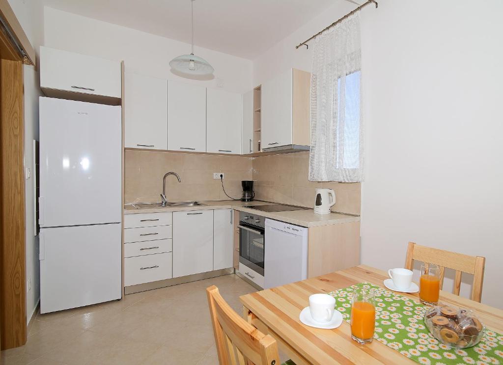 a kitchen with a wooden table and a dining room at Vista Apartments in Cavtat
