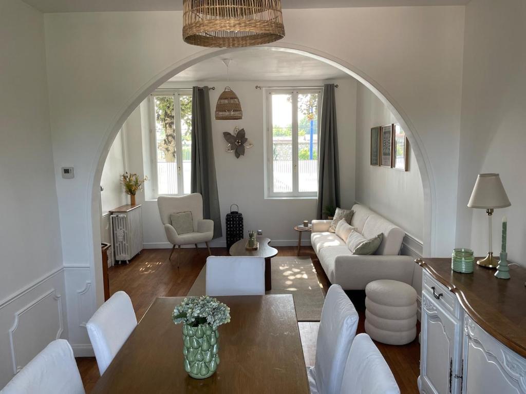 a living room with an archway and a table and chairs at La petite Compiégnoise in Margny-lès-Compiègne
