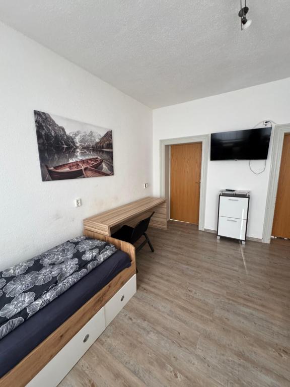 ゲーラにあるBüchner 50の部屋にベッドと机がある寝室