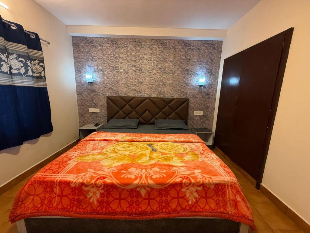 ウーティにあるgreen mountain homestayのベッドルーム1室(大型ベッド1台、オレンジの毛布付)