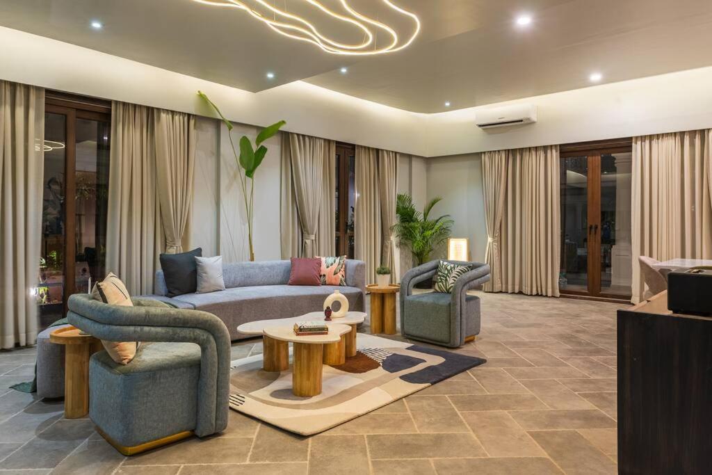 a living room with a couch and chairs and a table at Raina Villas Goa 6 bhk lux Pvt Pool in Arpora