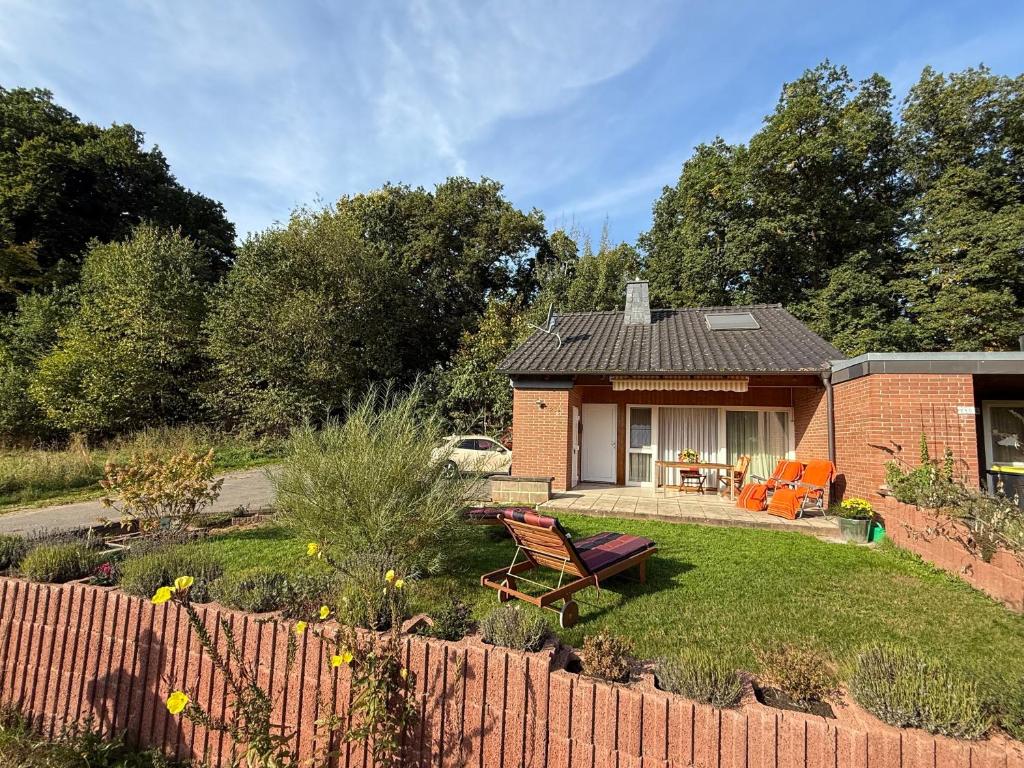 a brick house with a garden and a fence at Ferienhaus Waldwinkel in Wrexen