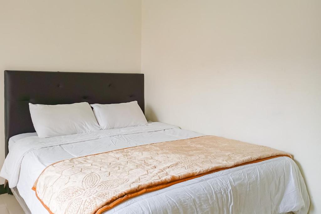 a bed with white sheets and white pillows at Homestay Nusa Indah 2 Syariah at Dieng 0 KM RedPartner in Dieng