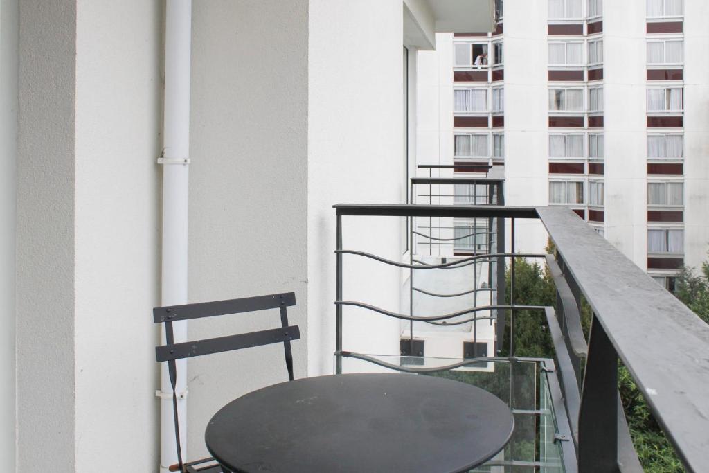 a table and two chairs on a balcony at Bright studio apartment with parking and balcony in Issy-les-Moulineaux