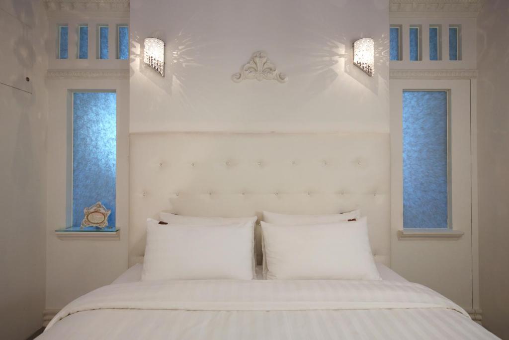 a bedroom with two white pillows and two windows at White Rabbit in Hualien City