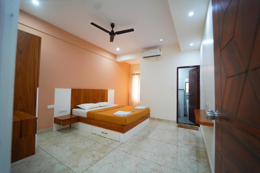 a bedroom with a bed and a ceiling fan at Nandan Enclave in Mysore