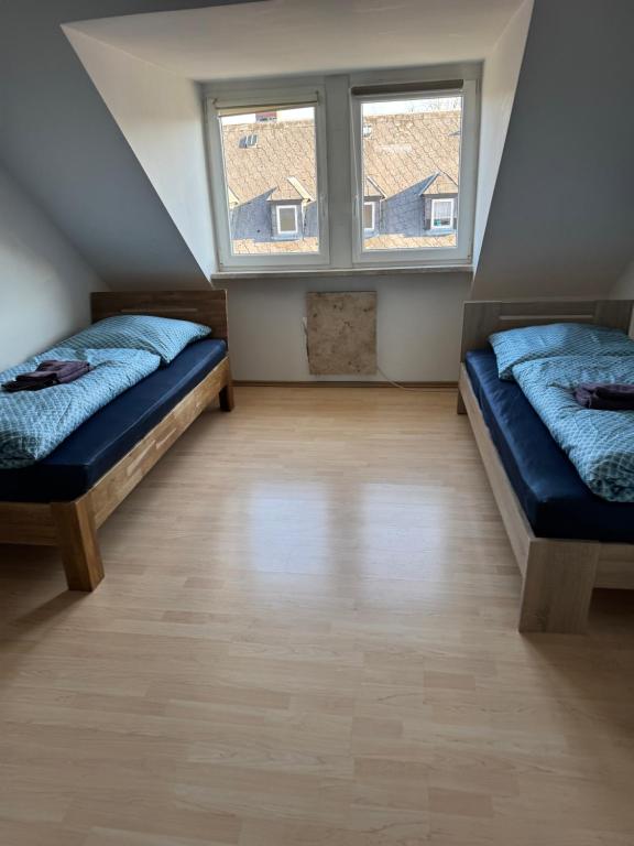 two beds in a room with a window at Leimitzer in Hof
