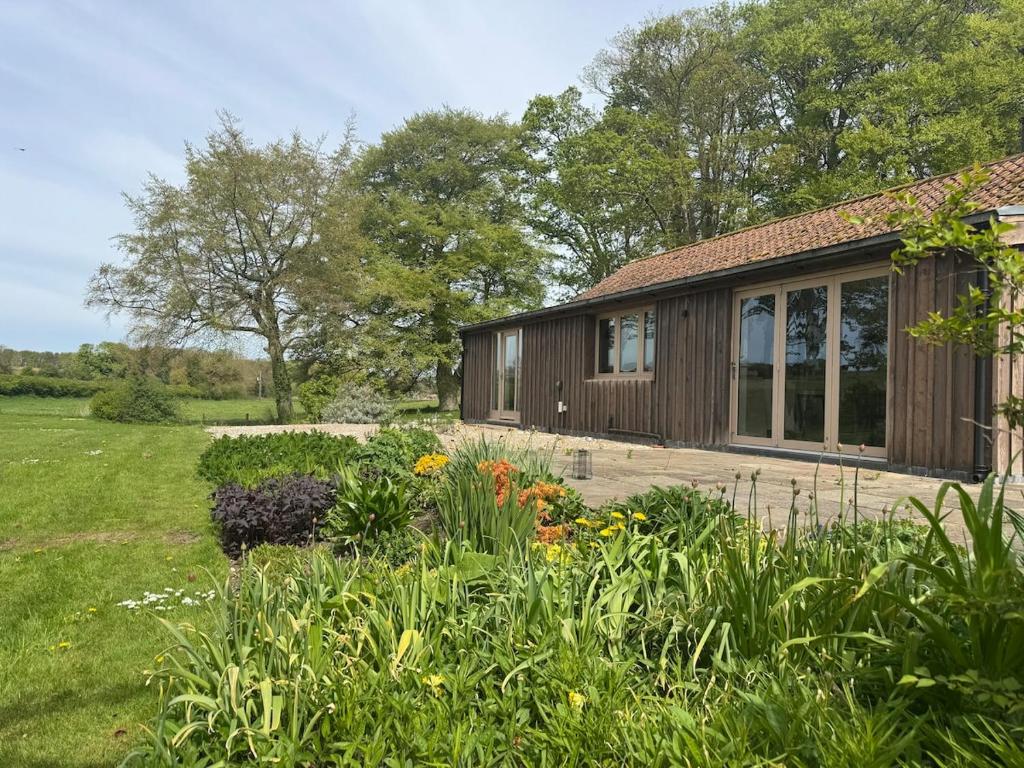 una casa con un jardín delante de ella en A converted Coach House, en Wold Newton