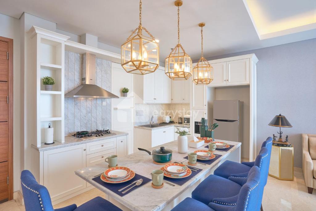 Una cocina y un comedor con una mesa y sillas azules. en Maison Verte - 3 BR Forest View - Dago Suites, en Bandung