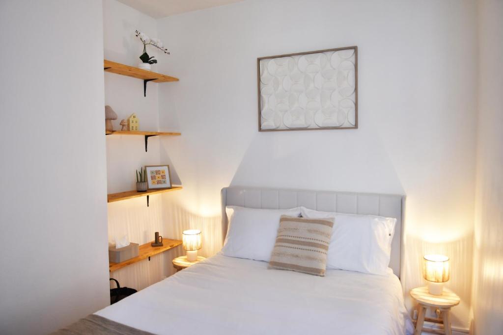 a bedroom with a white bed with two lamps at Le Petit Cèpe - Hyper Centre Bergerac in Bergerac