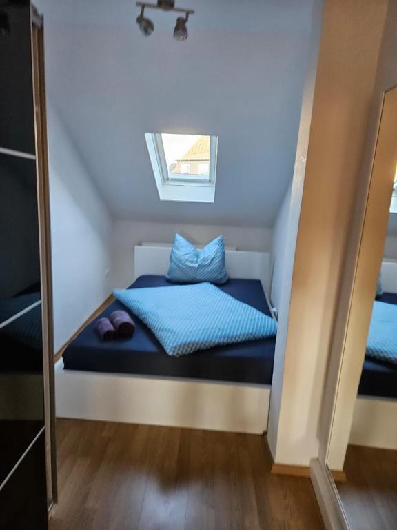 ein Schlafzimmer mit einem Bett mit blauer Bettwäsche und einem Fenster in der Unterkunft Theresie in Hof