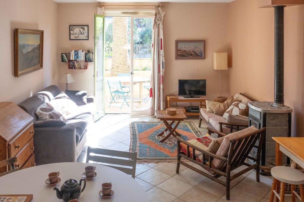 a living room with a couch and a table at Maison cosy 75m² – Porquerolles Immobilier in Porquerolles