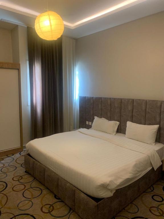 a bedroom with a large bed in a room at المضياف الذهبية للشقق المخدومة in Abha