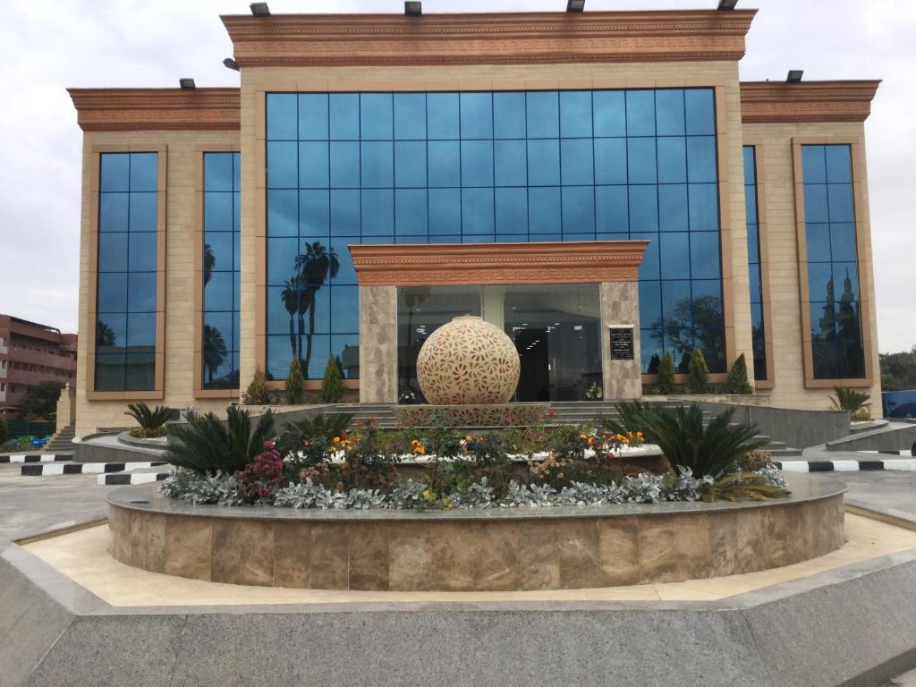 un grande edificio con una grande scultura di fronte di Jewel Inn Beni Suef a Beni Suef