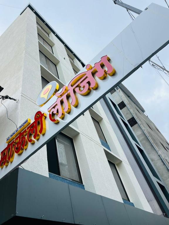 a large neon sign on the side of a building at Hotel Mauli Lodging in Ahmadnagar