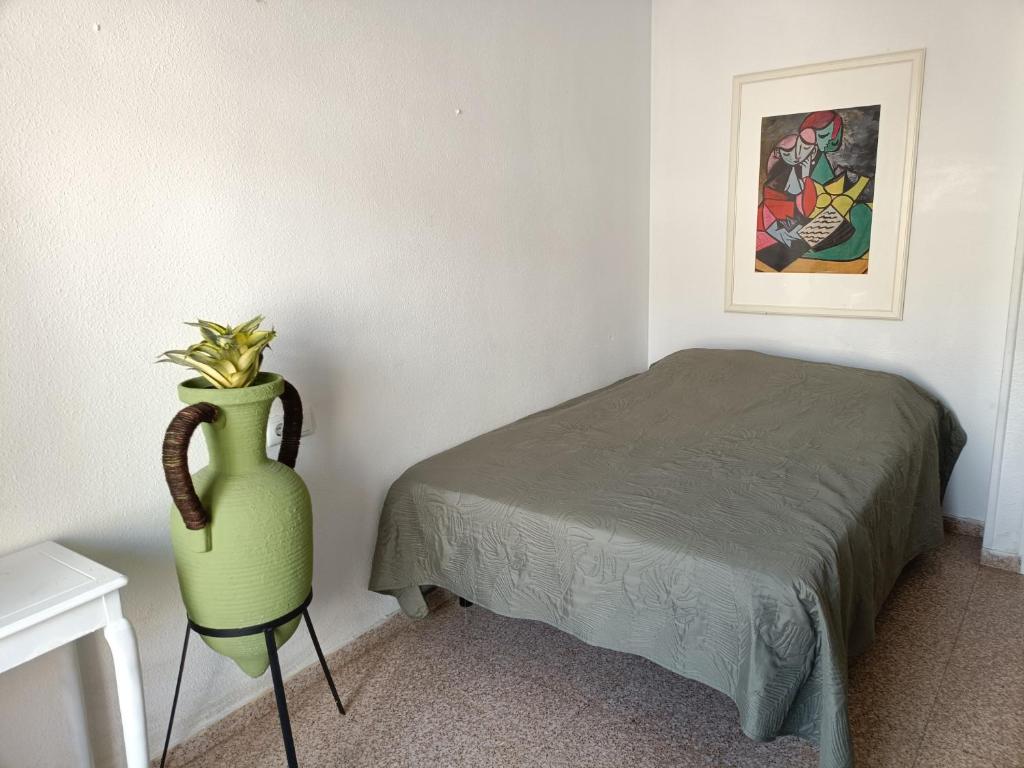 a bedroom with a bed and a green vase next to a bed at Casa Marquesa in Rojales