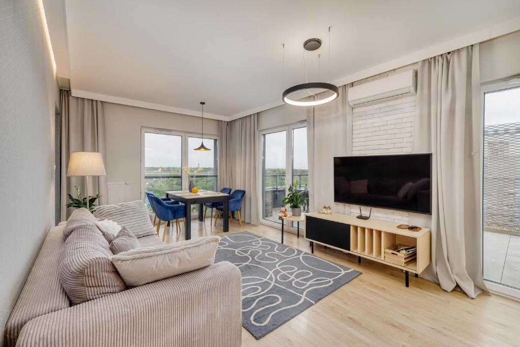 a living room with a couch and a tv at Sen Krasnala by FuzjaAparts in Wrocław