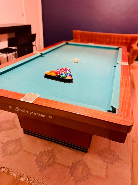 a pool table with a cue and balls on it at Modern 7-Bedroom Villa for Large Families & Groups in Rødby