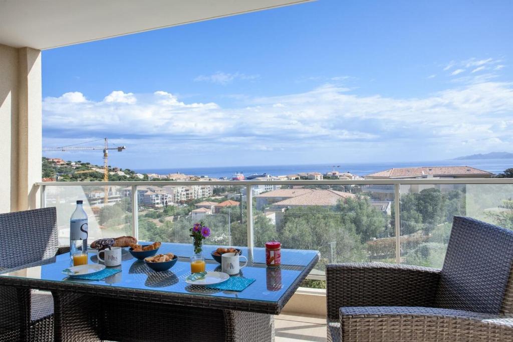 een tafel met eten en drinken bovenop een balkon bij Casa Liblue in LʼÎle-Rousse