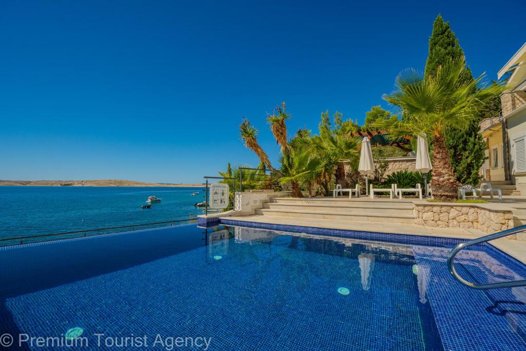 a swimming pool with a view of the ocean at Villa Mia in Kustići