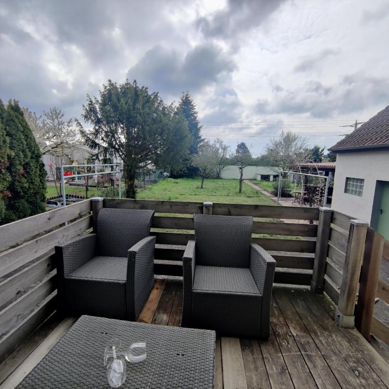 a patio with two chairs and a table on a deck at Schaefer Apartments - Residence Gardenview in Mühlheim