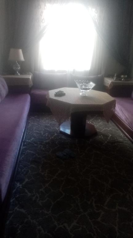 Cette chambre comprend une table, un lit et une fenêtre. dans l'établissement Appt, à Zemmour Touirza