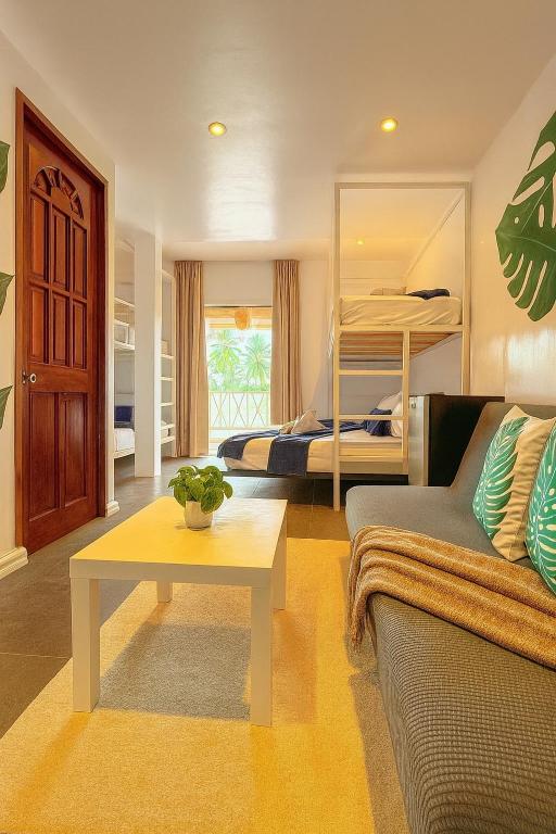 a living room with a couch and a table at The Blue Doors- Siargao in General Luna